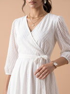 Woman wearing a white dress with a beige background