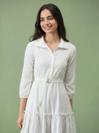 Woman wearing a white dress against a green background