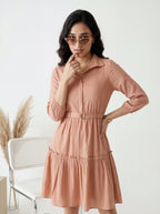 Woman wearing a peach-colored dress with a white background