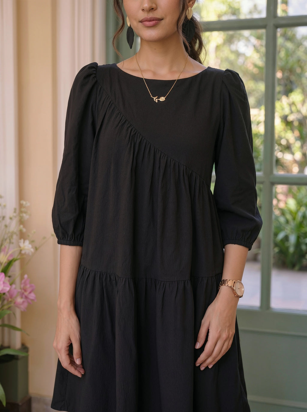 Woman wearing a black dress with a blurred outdoor background