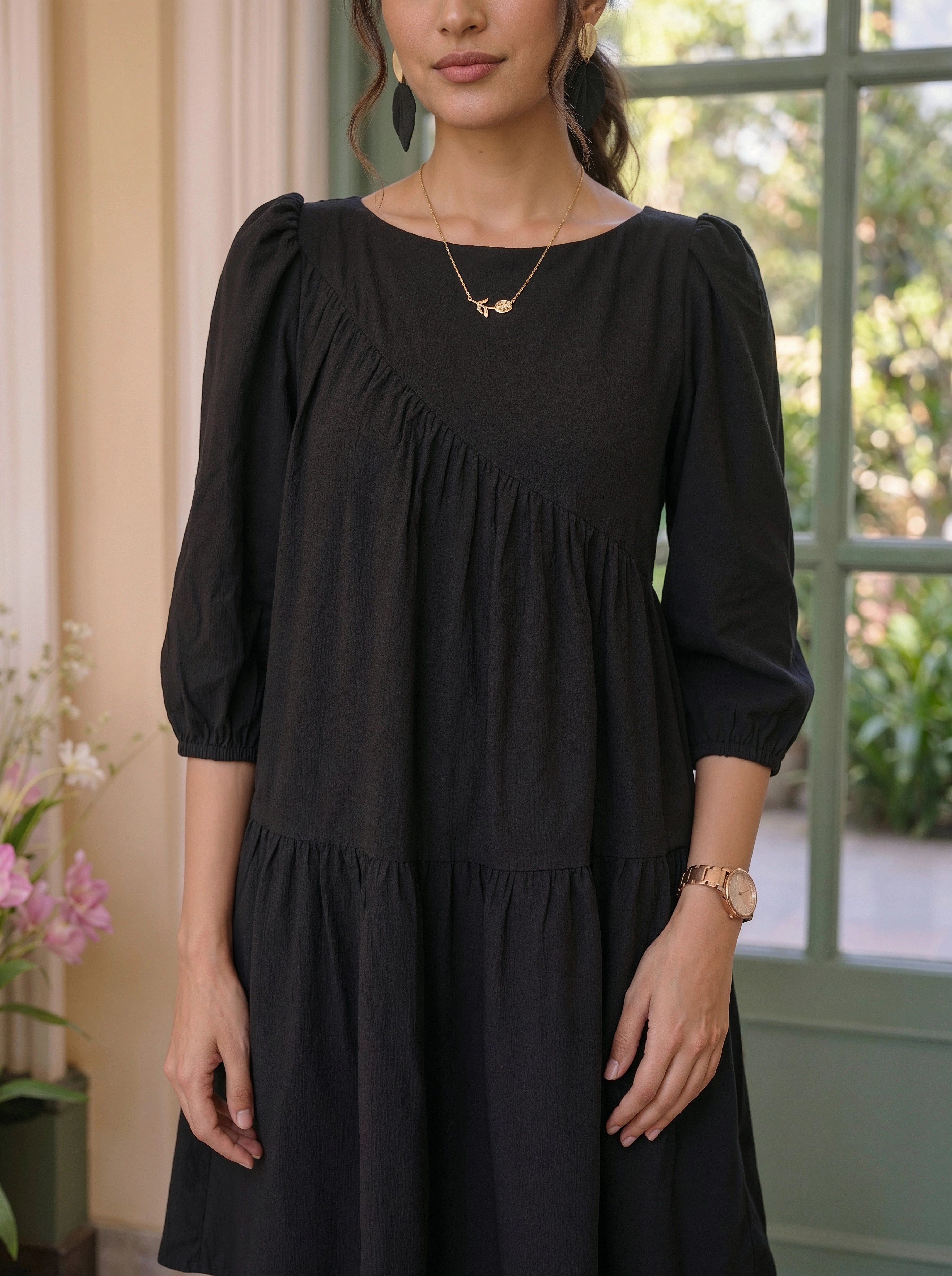 Woman wearing a black dress with a blurred outdoor background