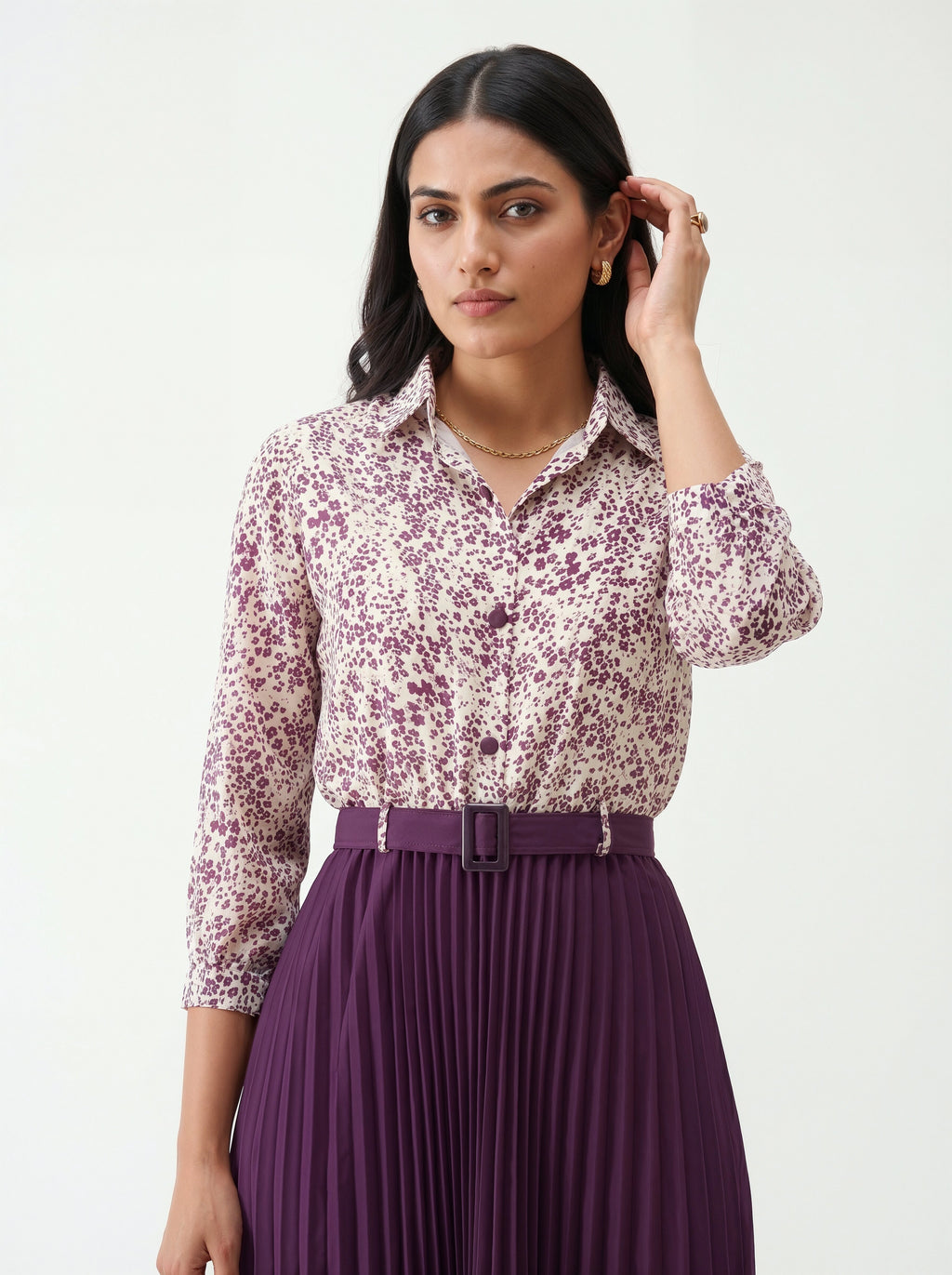 Woman wearing a floral blouse and purple skirt on a white background