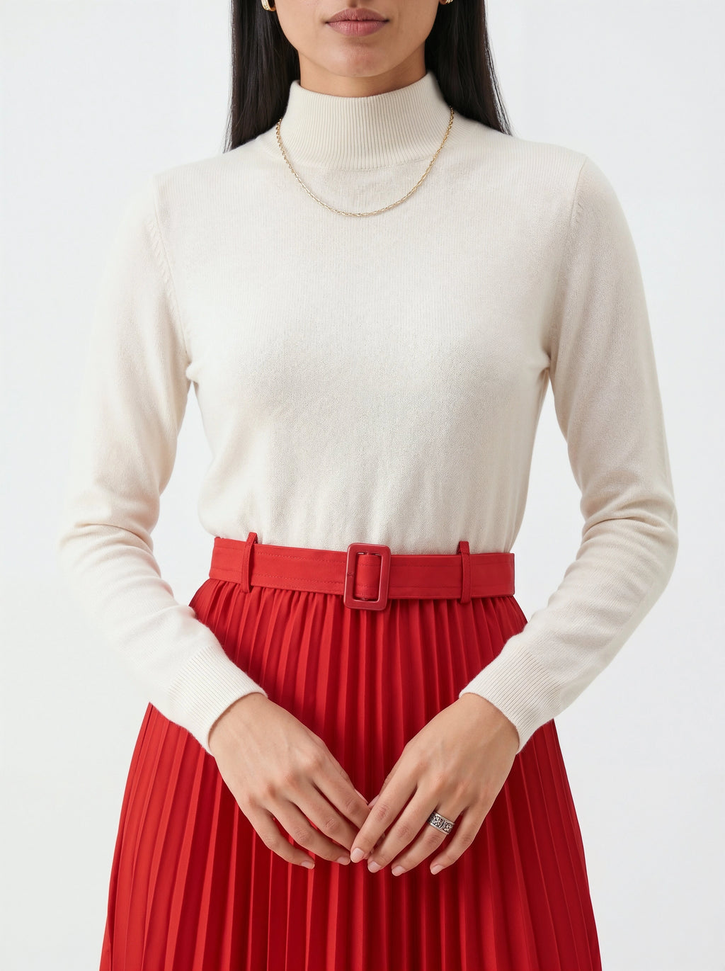 Person wearing a white turtleneck sweater and red pleated skirt on a white background