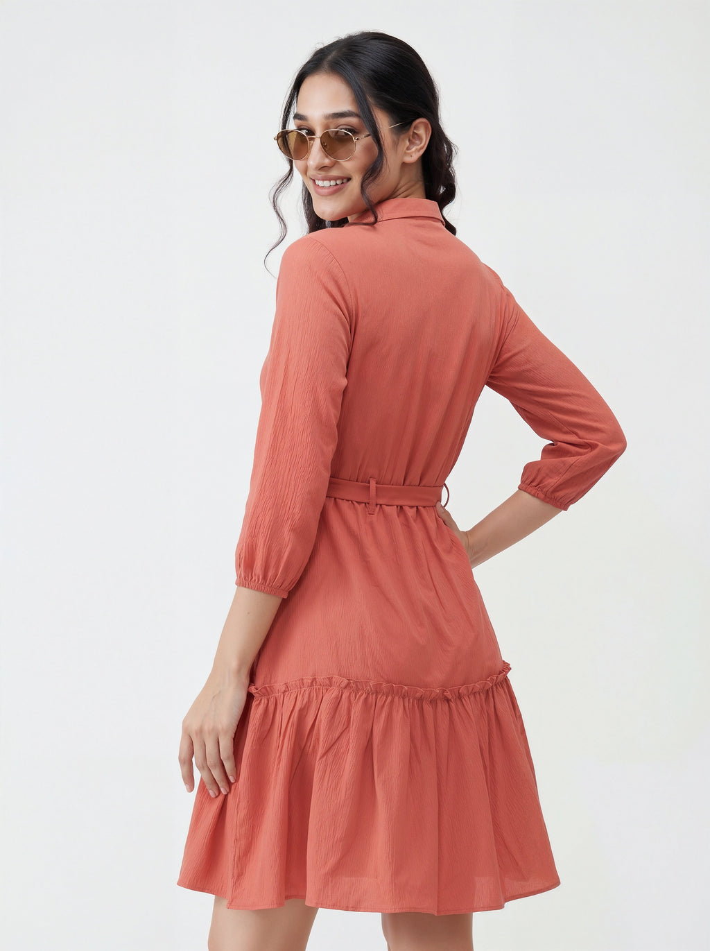Woman wearing a coral dress with a white background