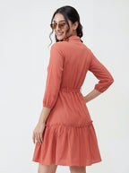 Woman wearing a coral dress with a white background