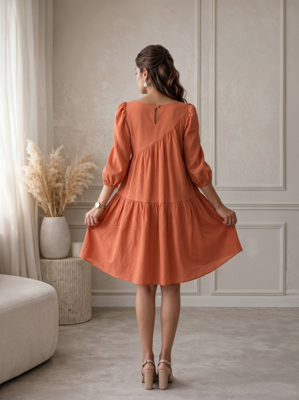 Woman wearing an orange dress in a room with neutral decor