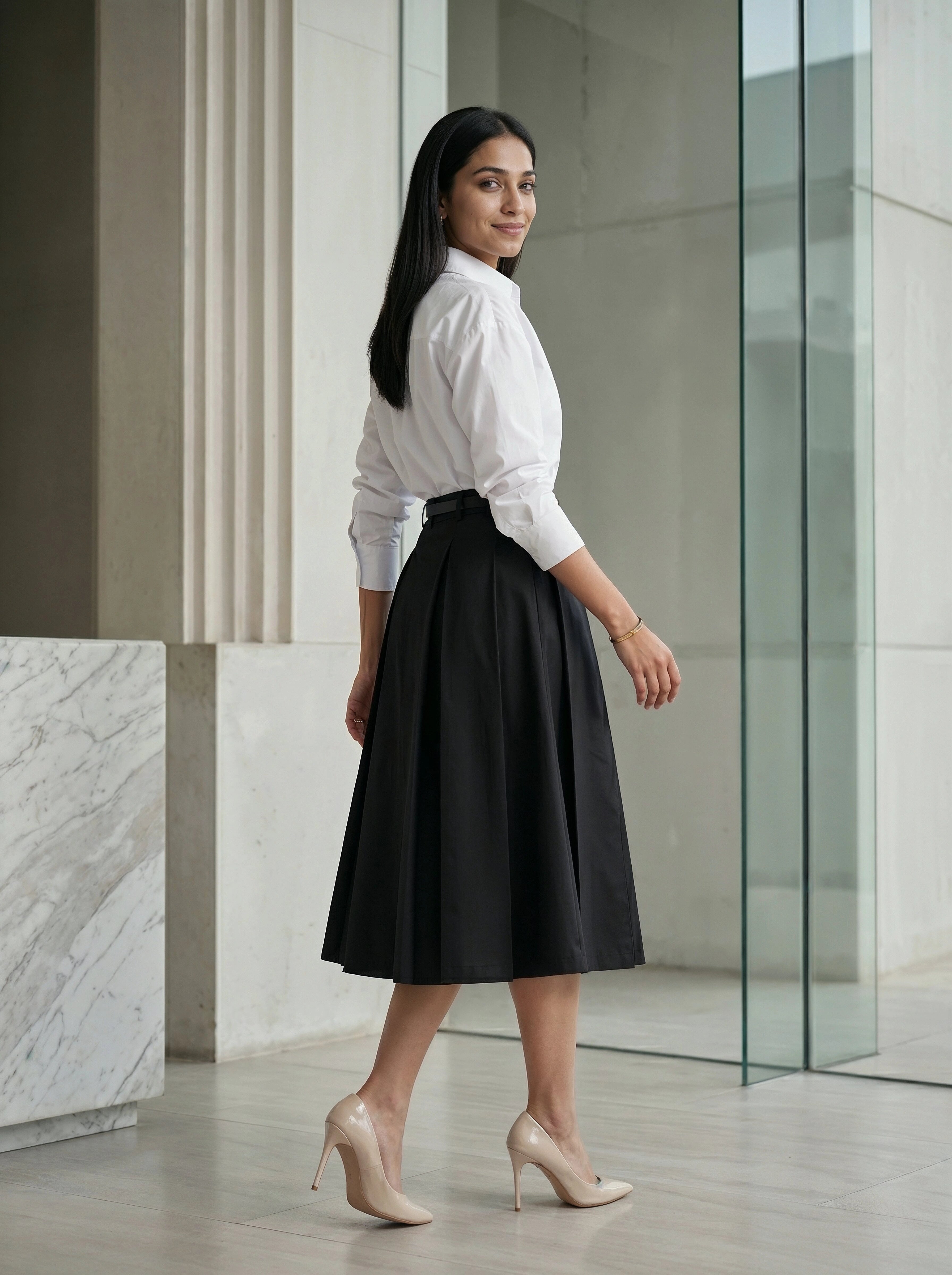 Woman wearing a white blouse and black skirt in an indoor setting
