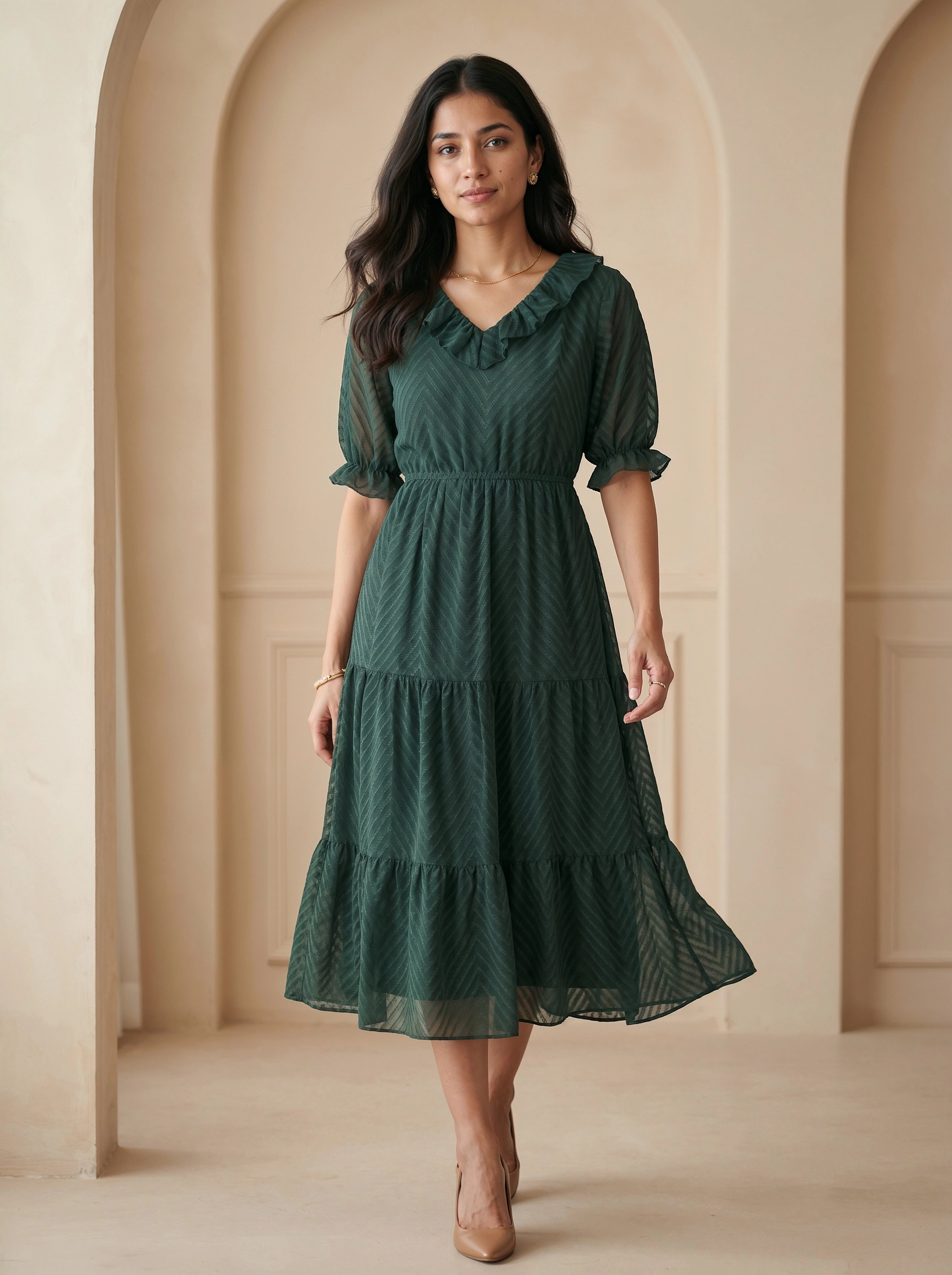 Woman wearing a green dress standing in an archway.