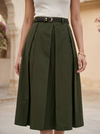 Person wearing a green skirt with a beige background