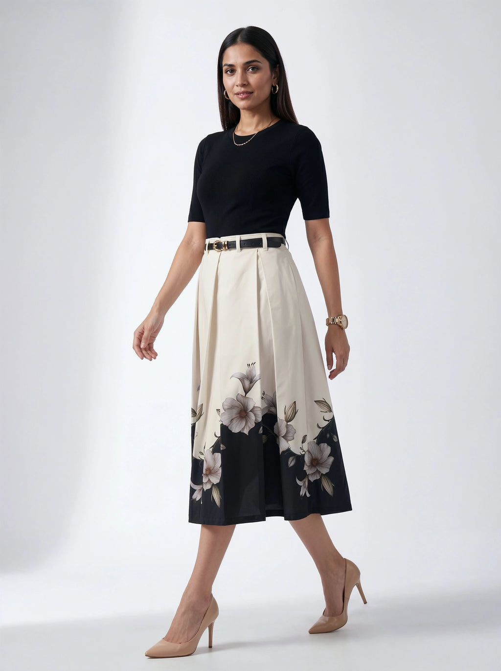 Woman wearing a black top and floral skirt on a white background