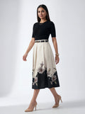Woman wearing a black top and floral skirt on a white background