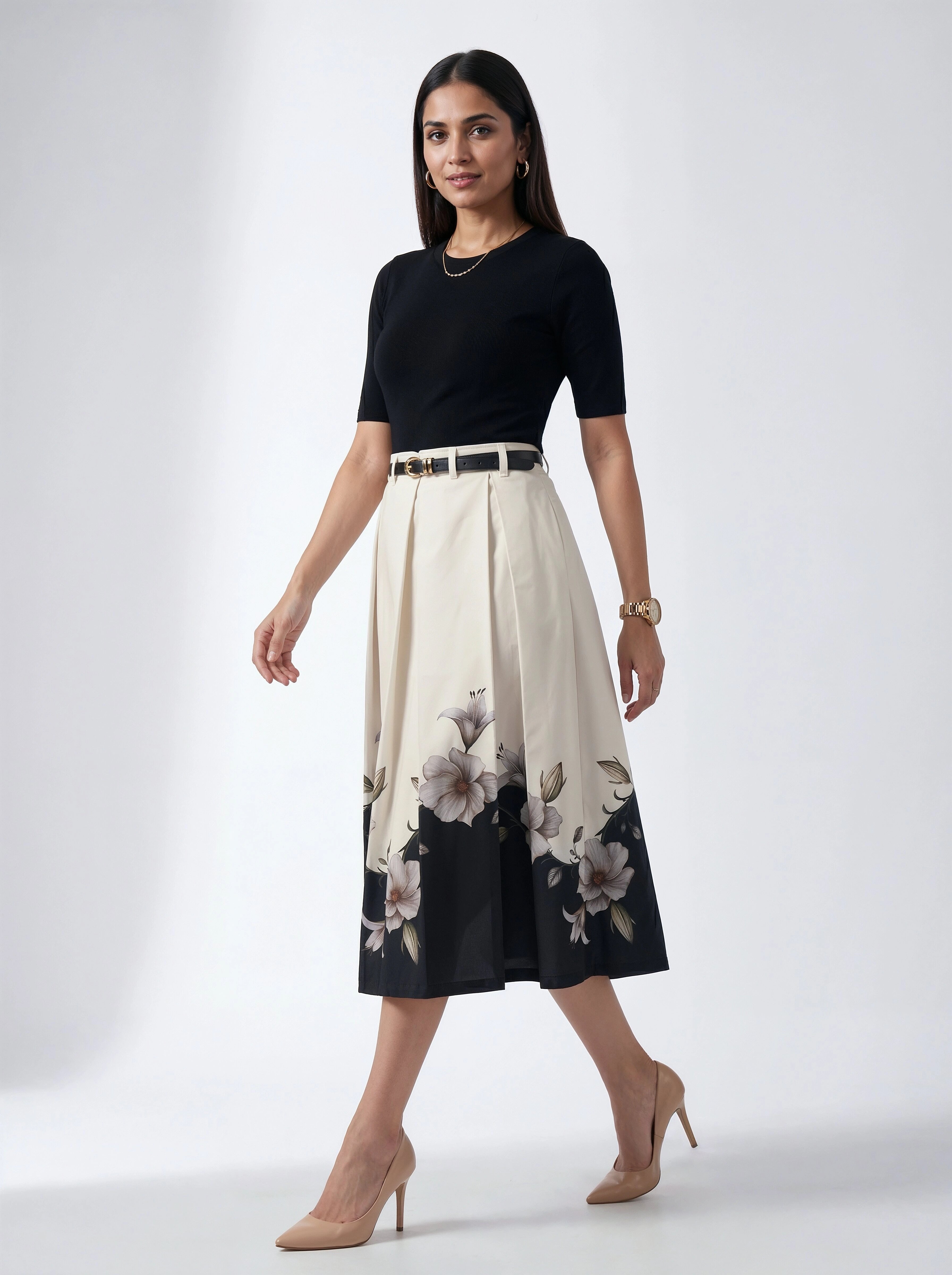 Woman wearing a black top and floral skirt on a white background