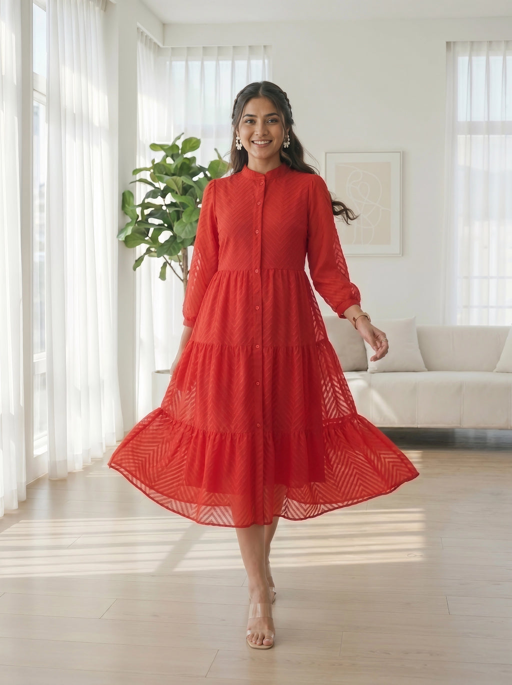 Woman in a red dress standing in a bright living room.