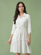 Woman wearing a white dress against a green background