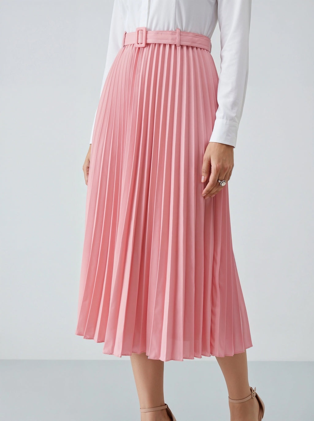 Person wearing a pink pleated skirt on a white background