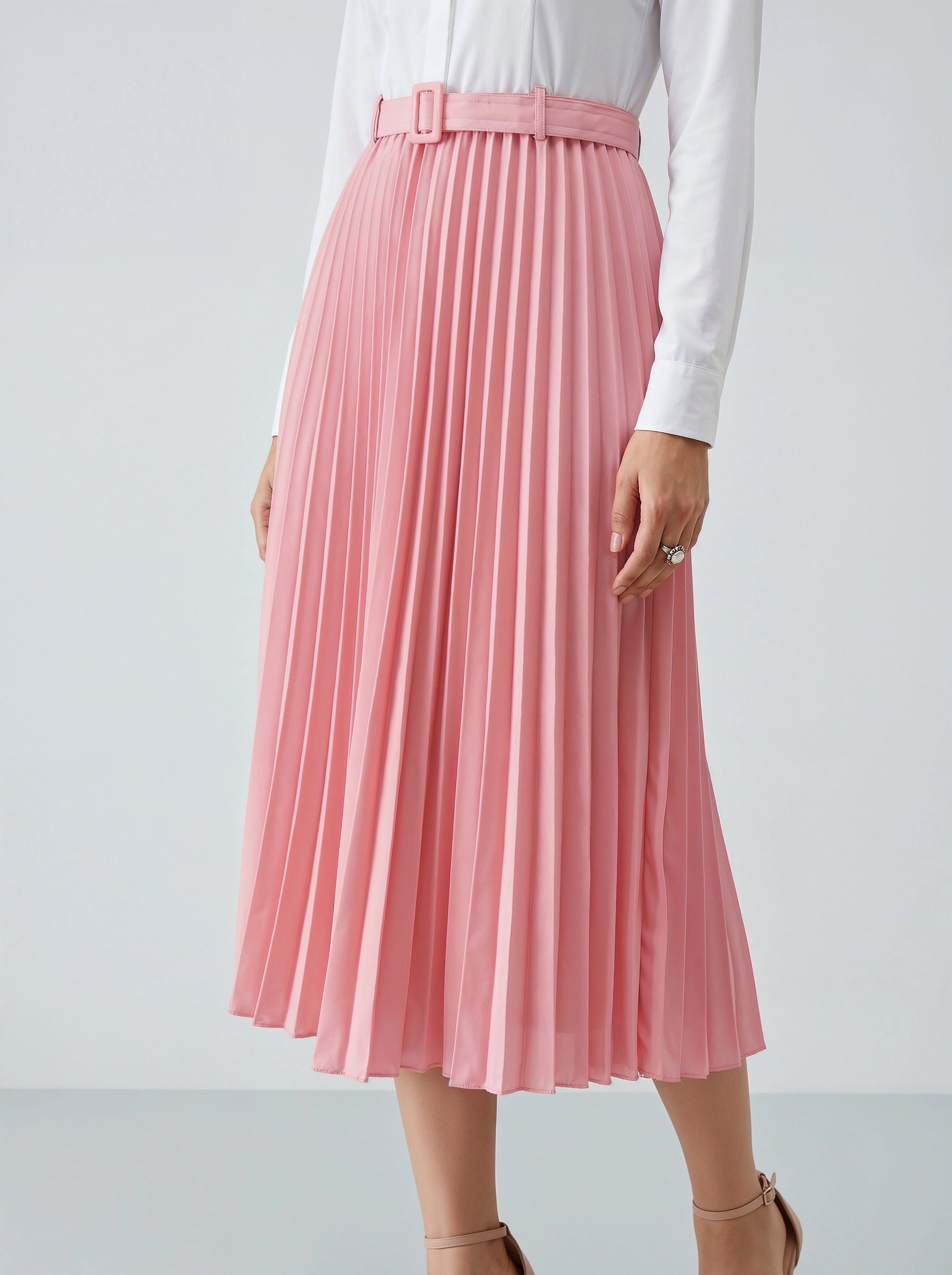 Person wearing a pink pleated skirt on a white background
