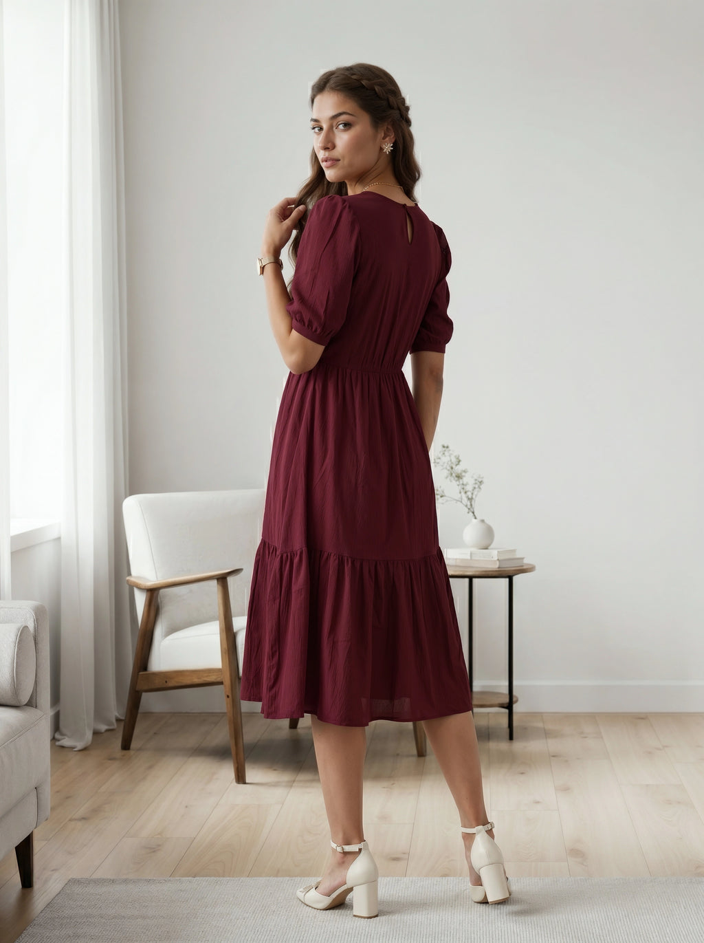 Woman in a burgundy dress standing in a room with neutral decor