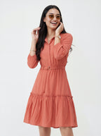Woman wearing a coral dress with a white background