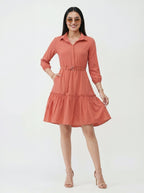 Woman wearing a coral dress on a white background