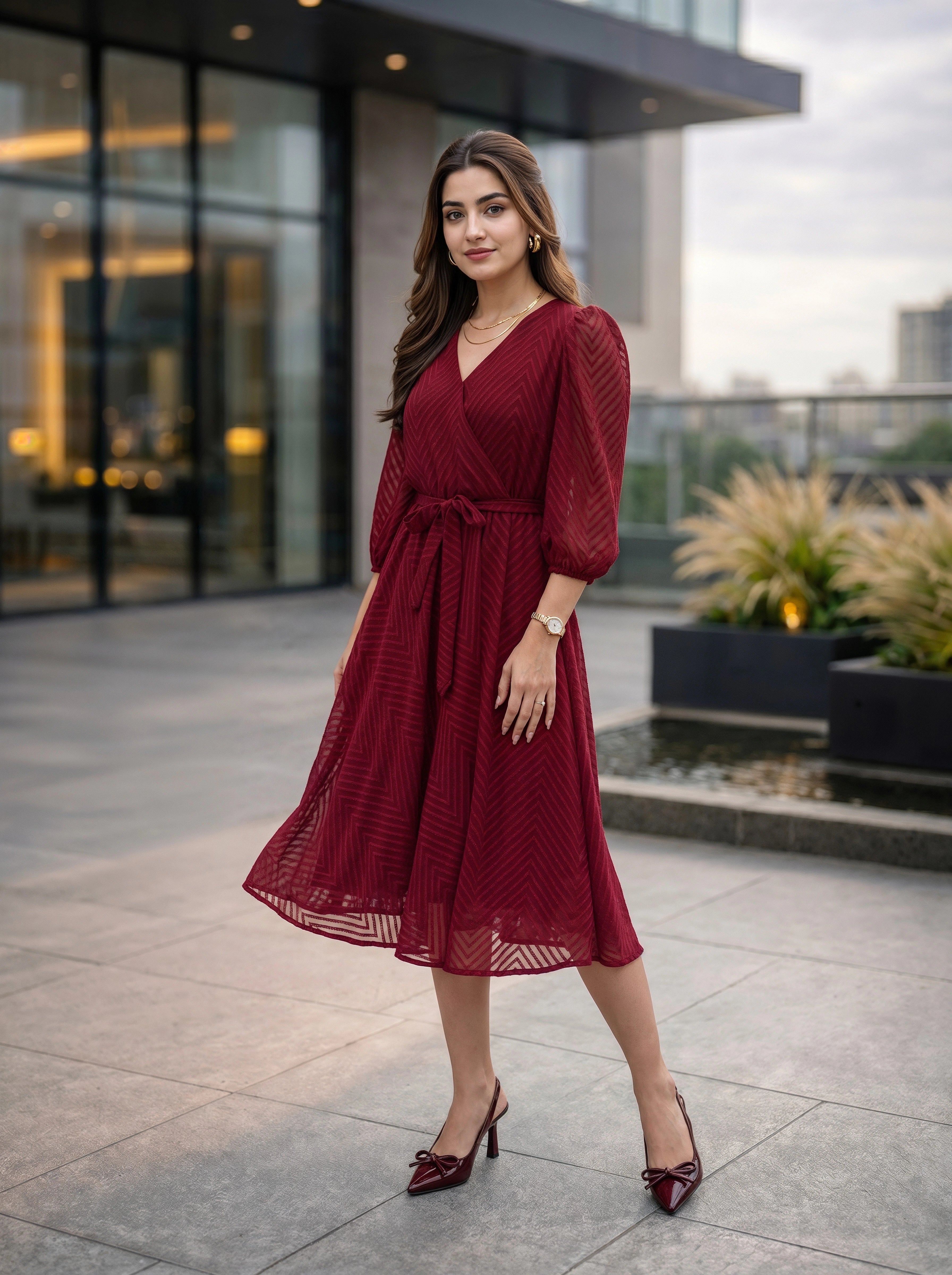 Woman in a red dress standing outdoors with modern building in the background