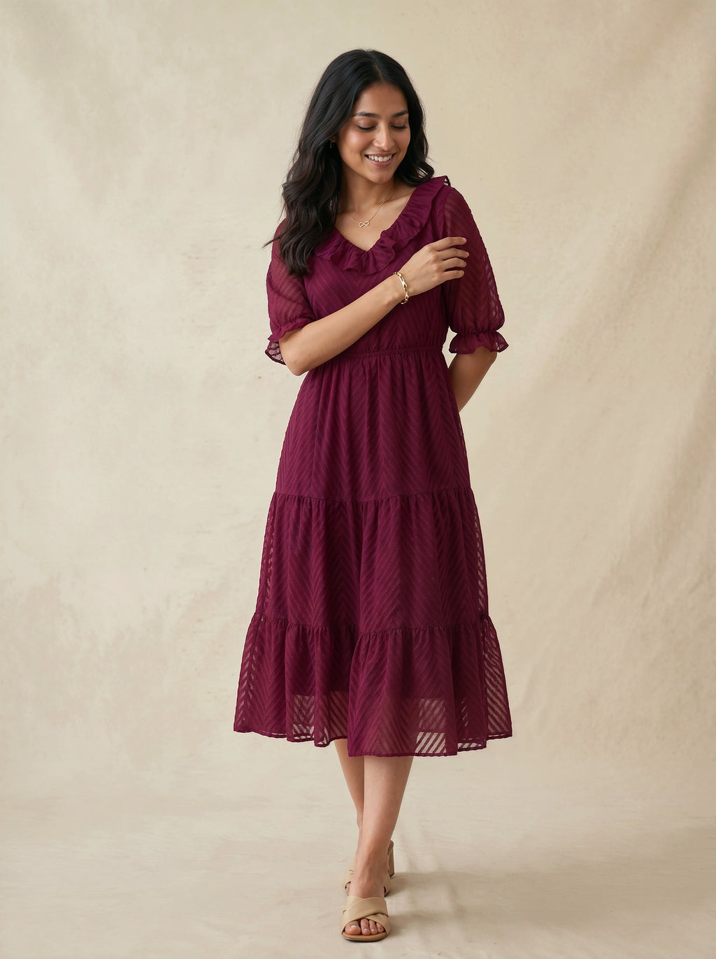 Woman wearing a burgundy dress against a beige background