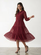 Woman wearing a burgundy dress with a white background