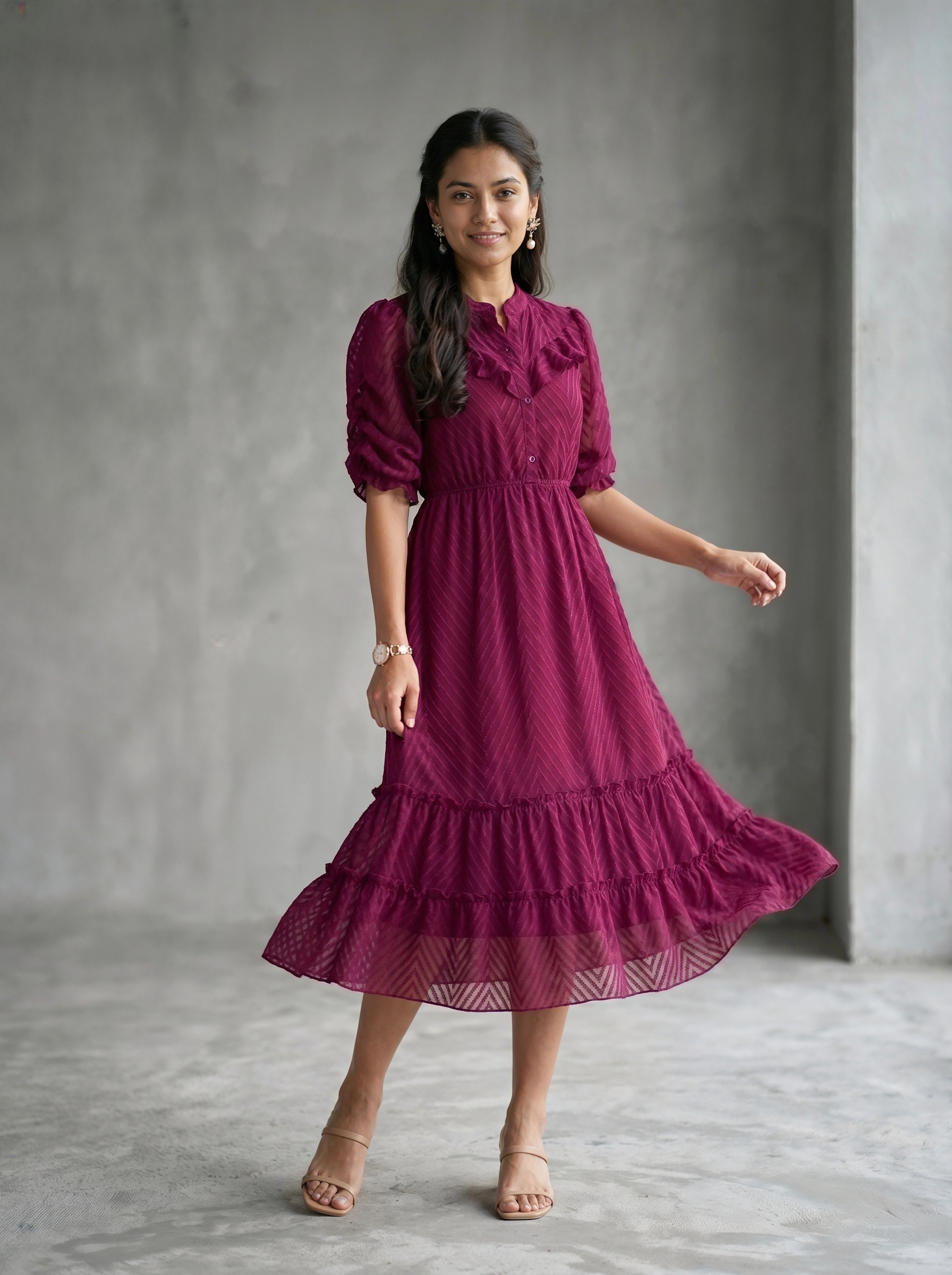Woman wearing a burgundy dress with a plain background