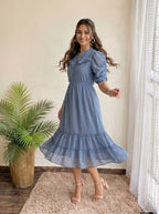 Woman wearing a patterned dress in an elegant hallway