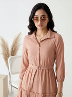 Woman wearing a pink dress with sunglasses indoors