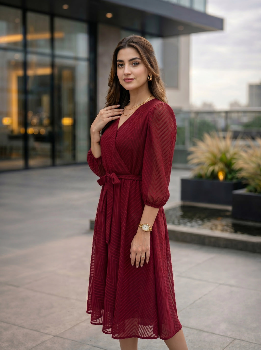 Woman in a red dress standing outdoors with modern building in the background