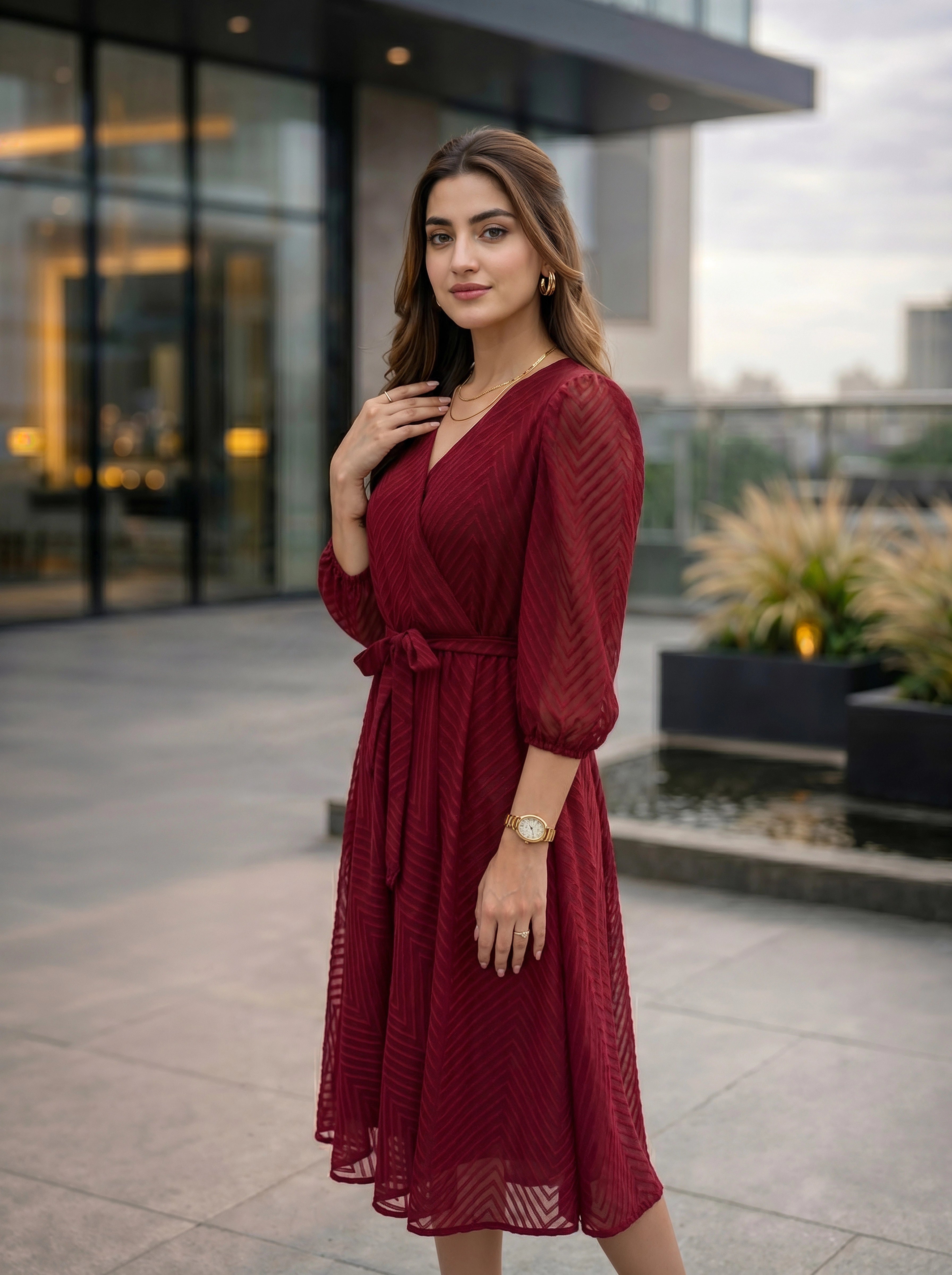 Woman in a red dress standing outdoors with modern building in the background