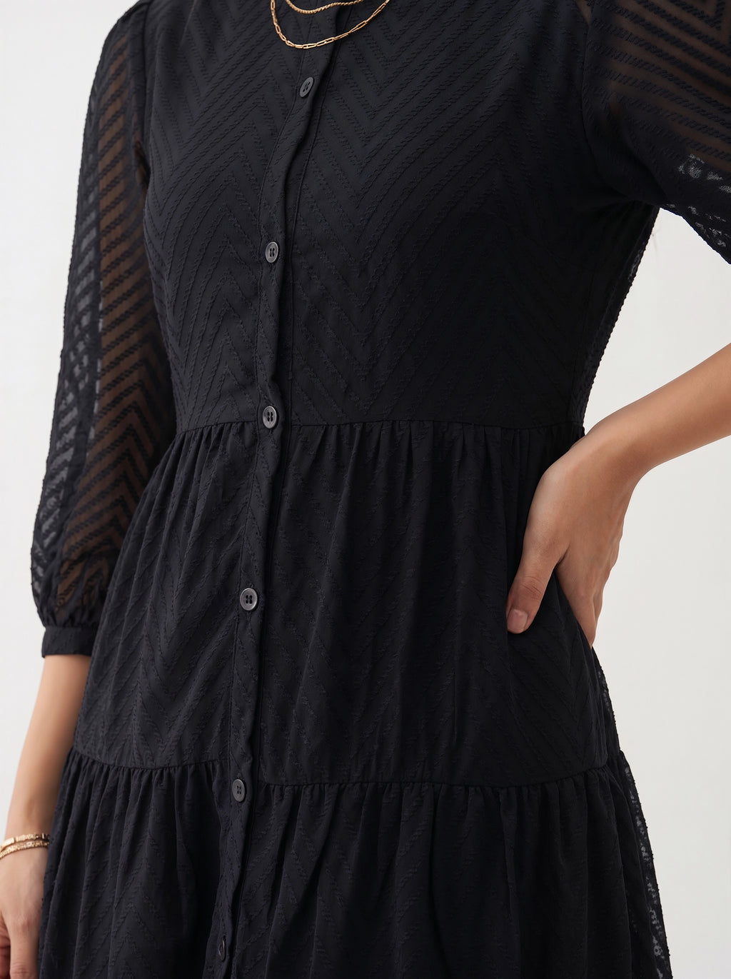 Black dress with sheer sleeves on a white background
