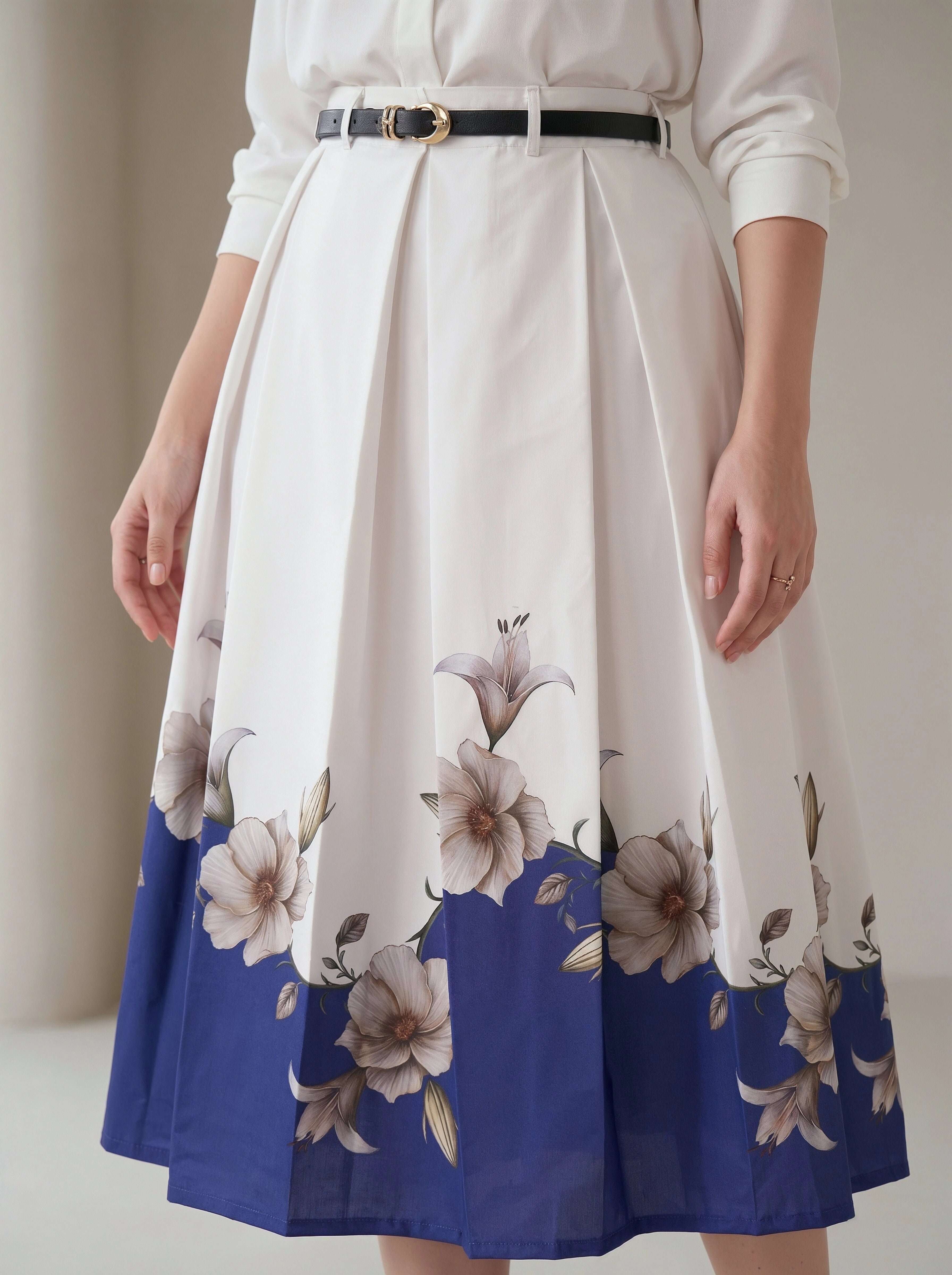 White blouse with a white and blue floral skirt on a neutral background