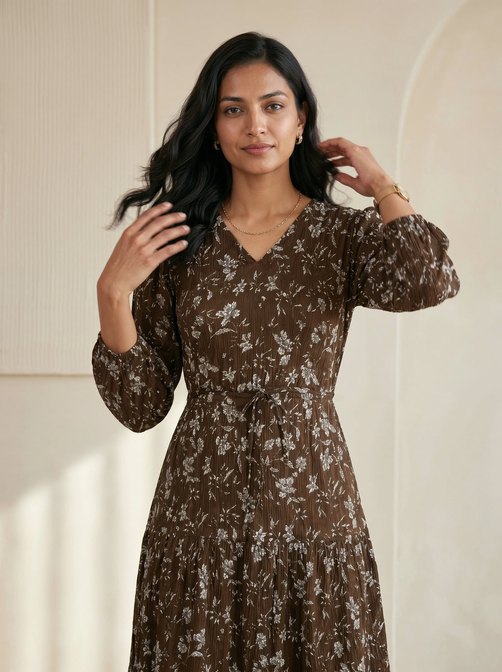 Woman wearing a brown floral dress against a neutral background