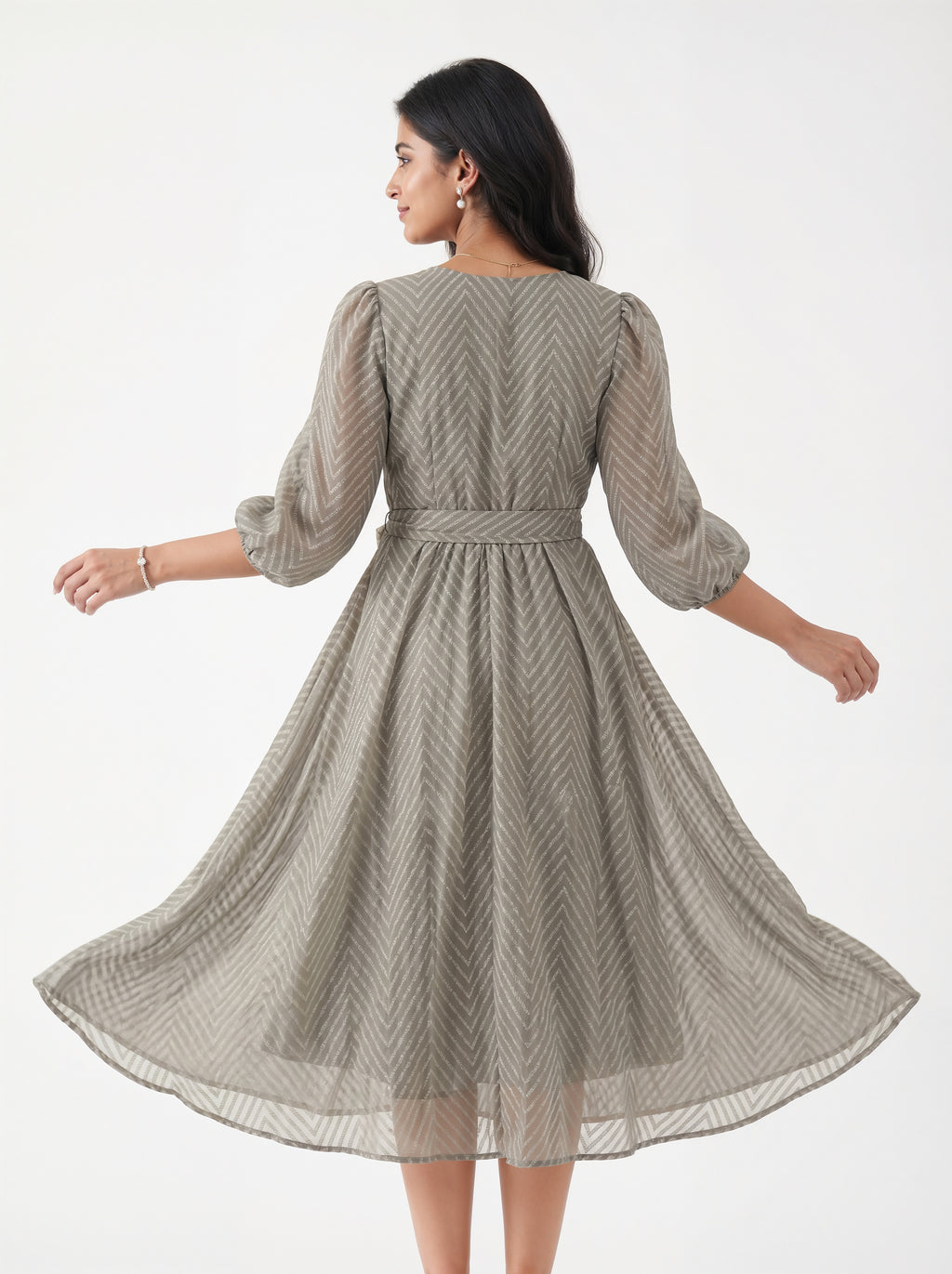 Woman wearing a beige patterned dress on a white background