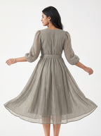 Woman wearing a beige patterned dress on a white background