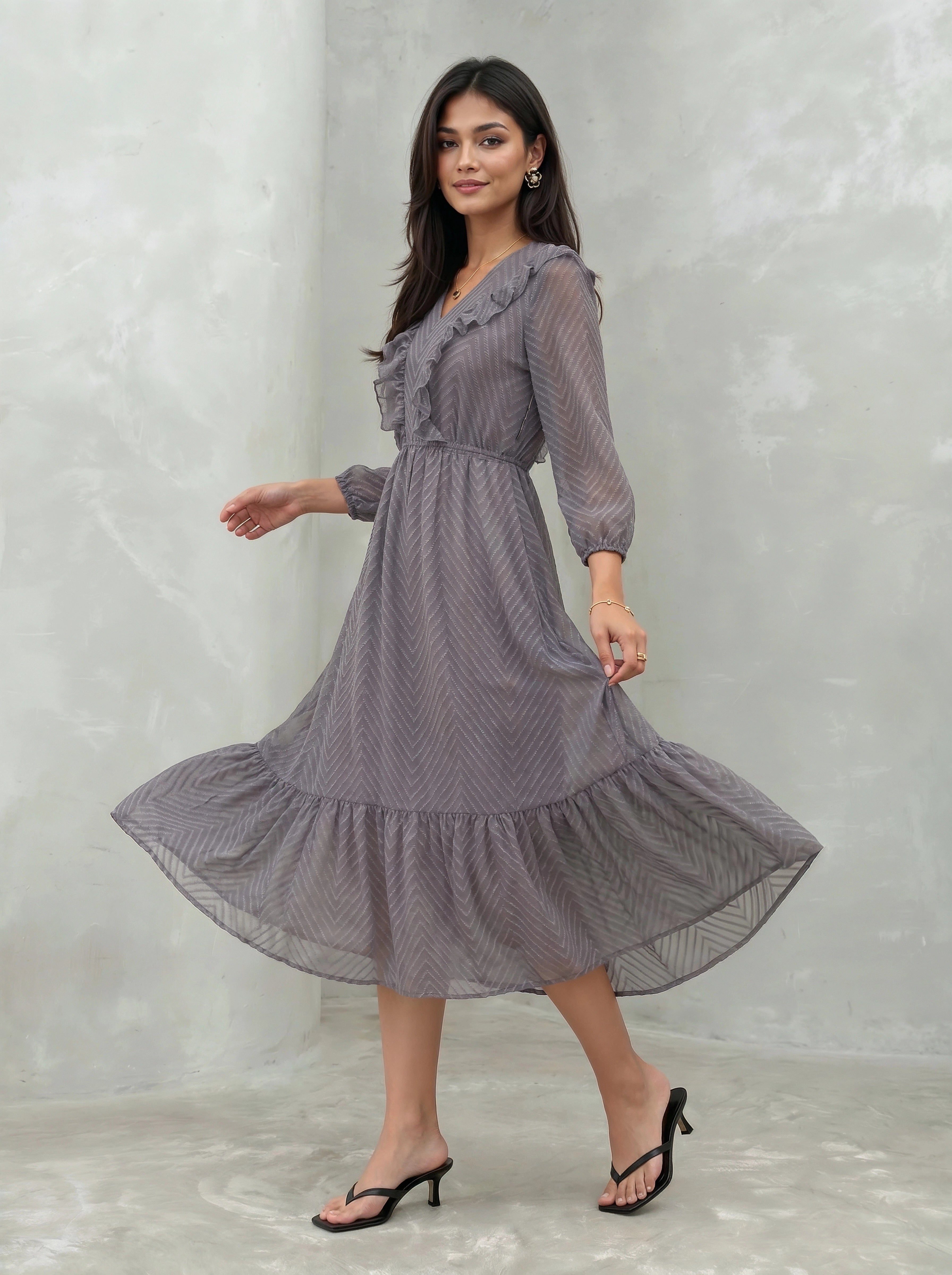 Woman wearing a long, patterned dress against a plain background