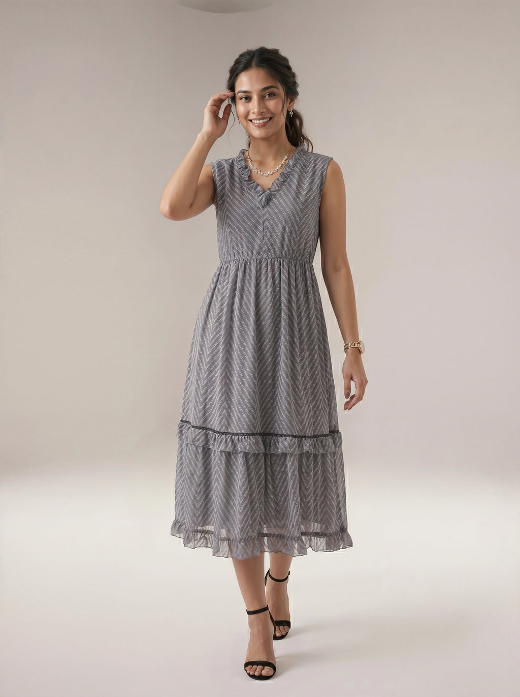 Woman wearing a gray patterned dress on a plain background