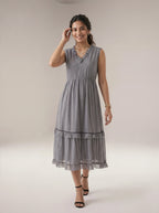 Woman wearing a gray patterned dress on a plain background