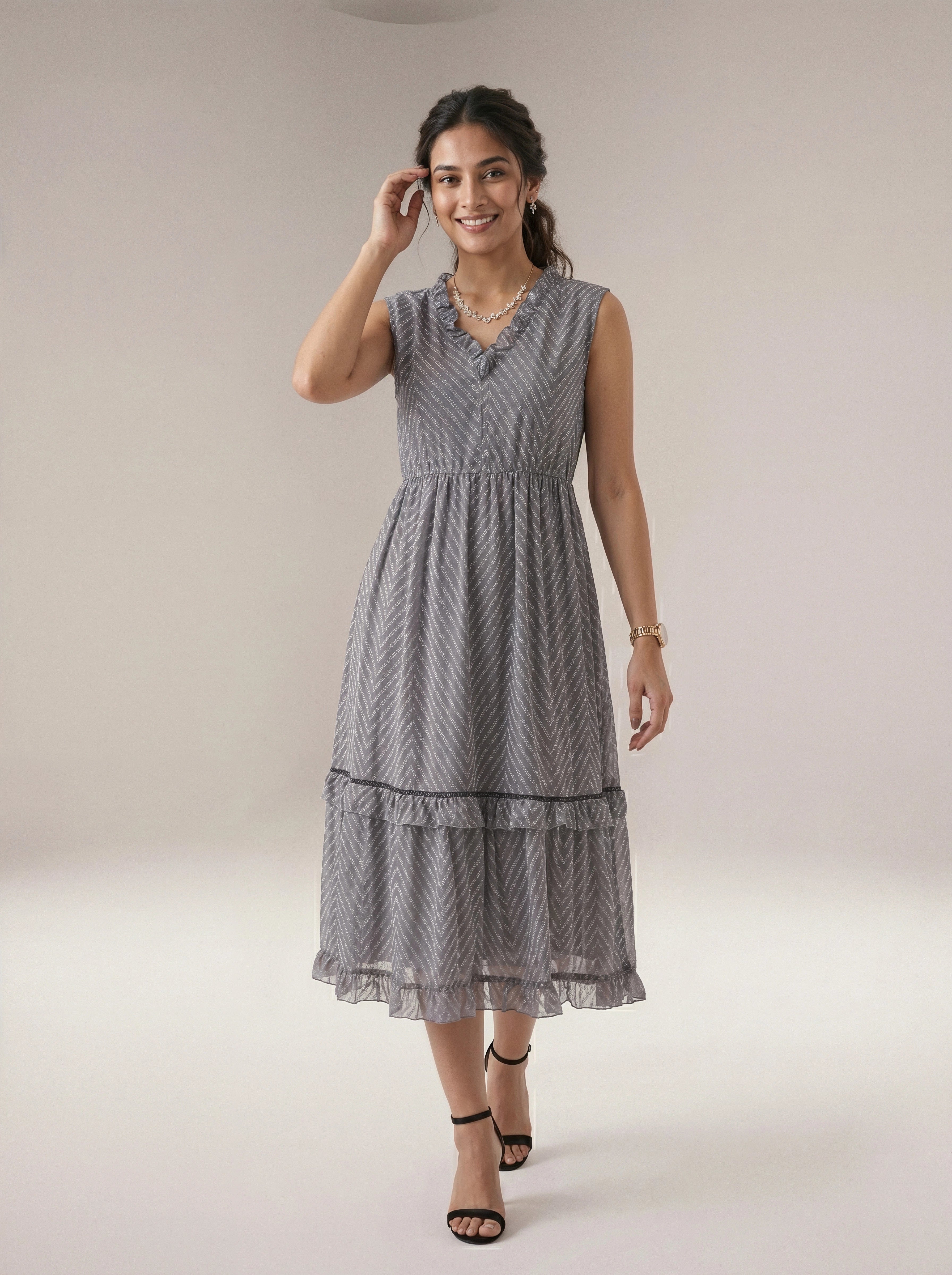 Woman wearing a gray patterned dress on a plain background