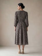 Woman wearing a floral dress against a plain background