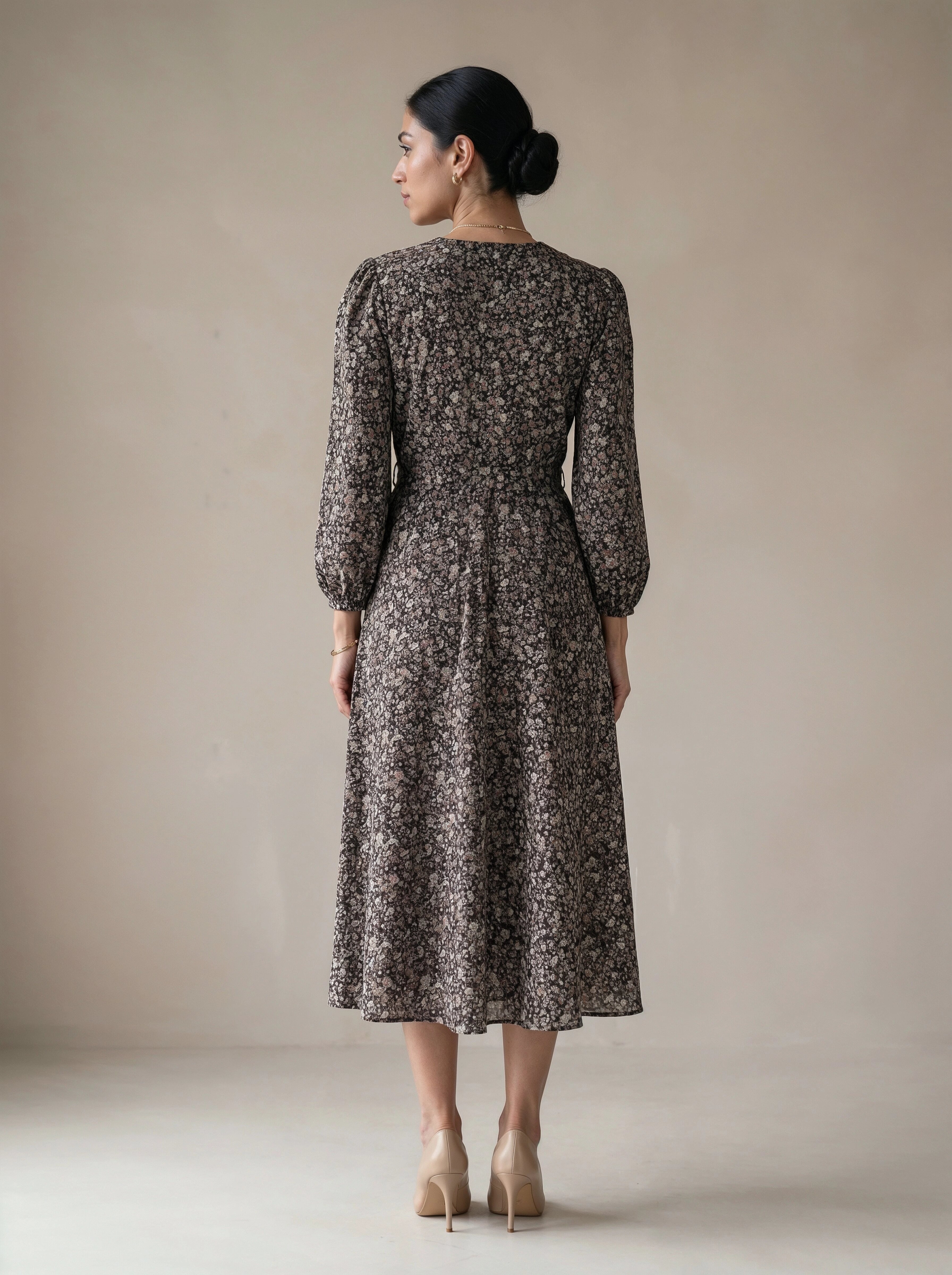 Woman wearing a floral dress against a plain background