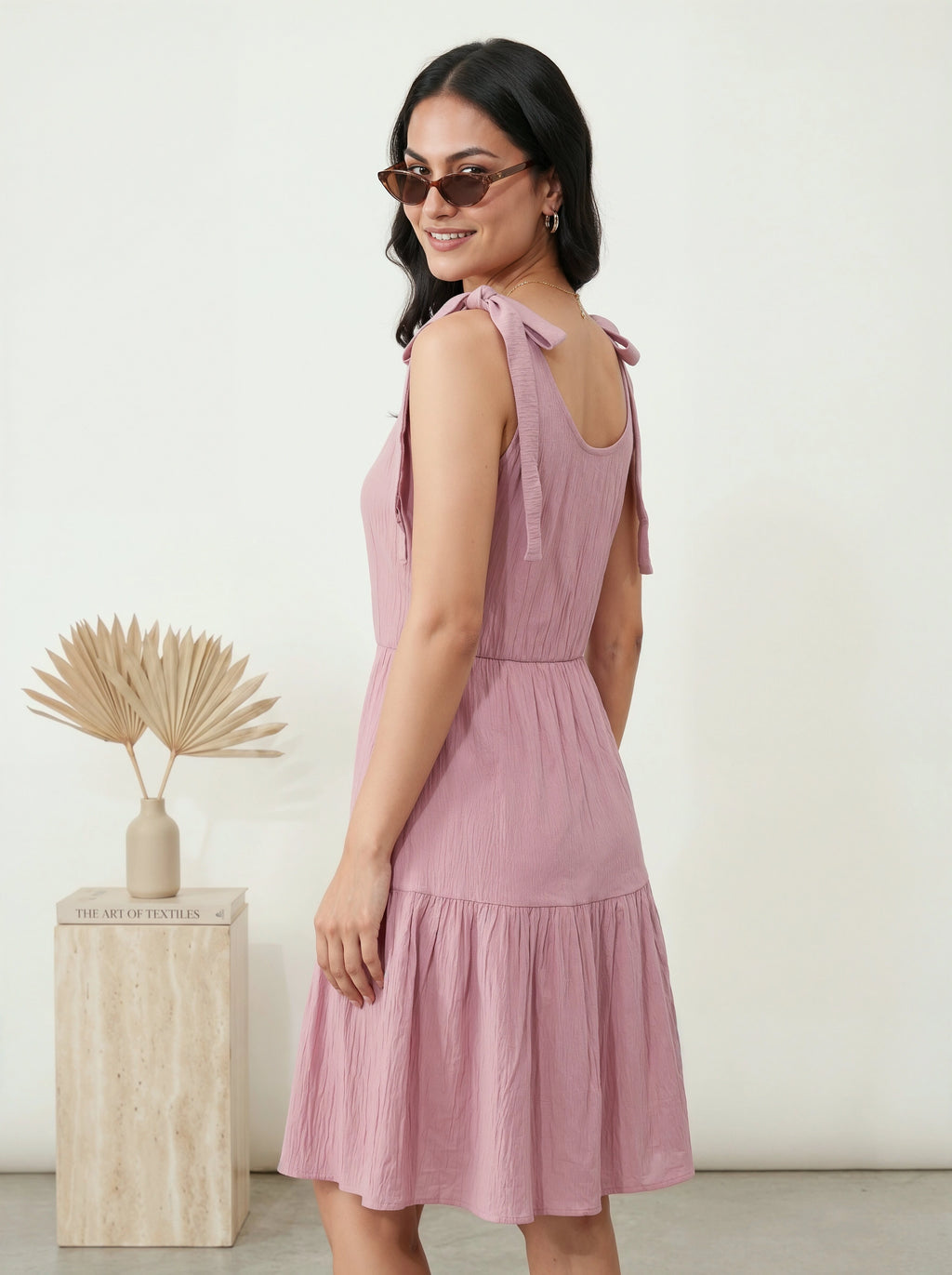 Woman wearing a pink dress with a white background