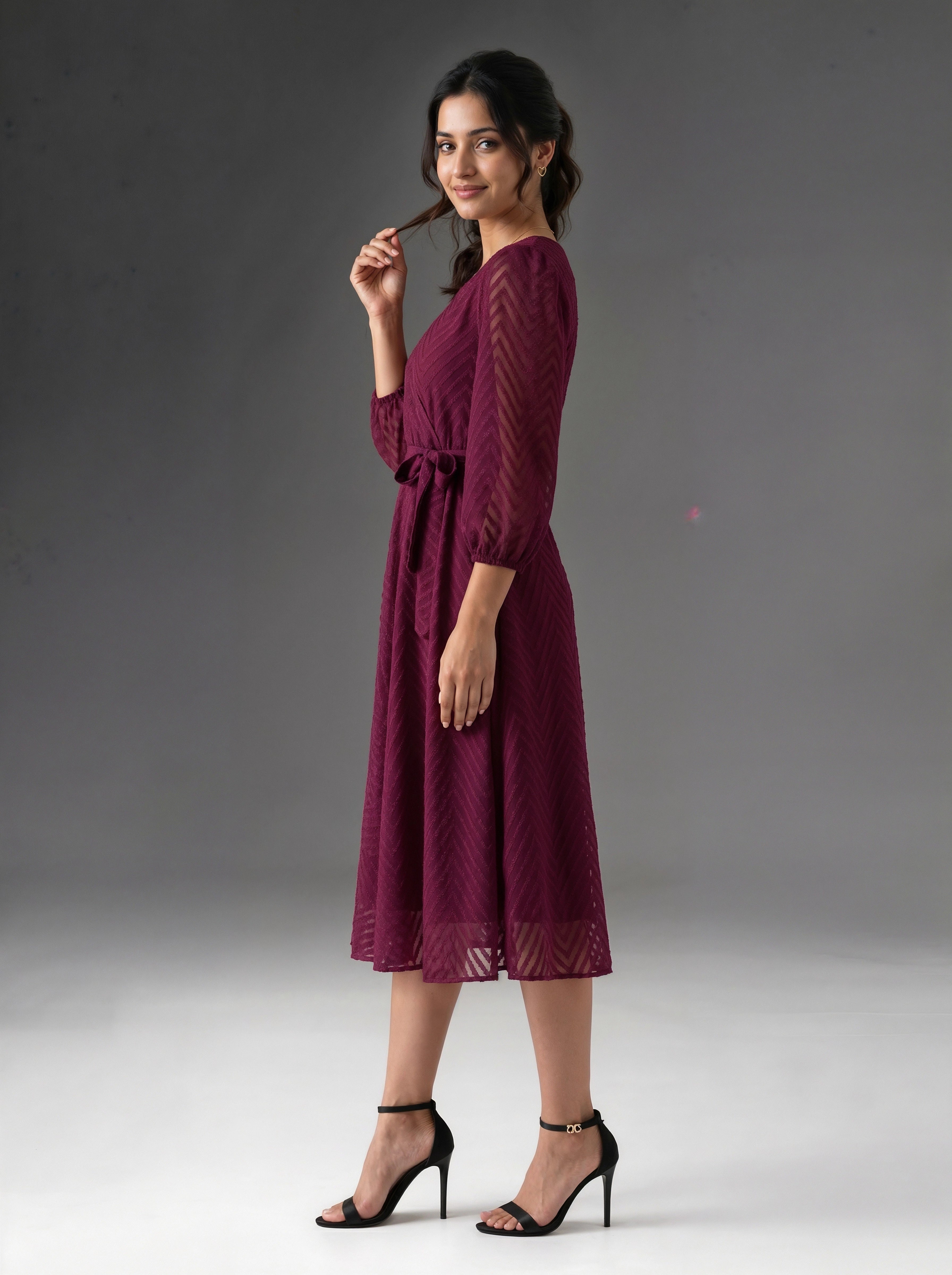 Woman wearing a burgundy dress against a gray background