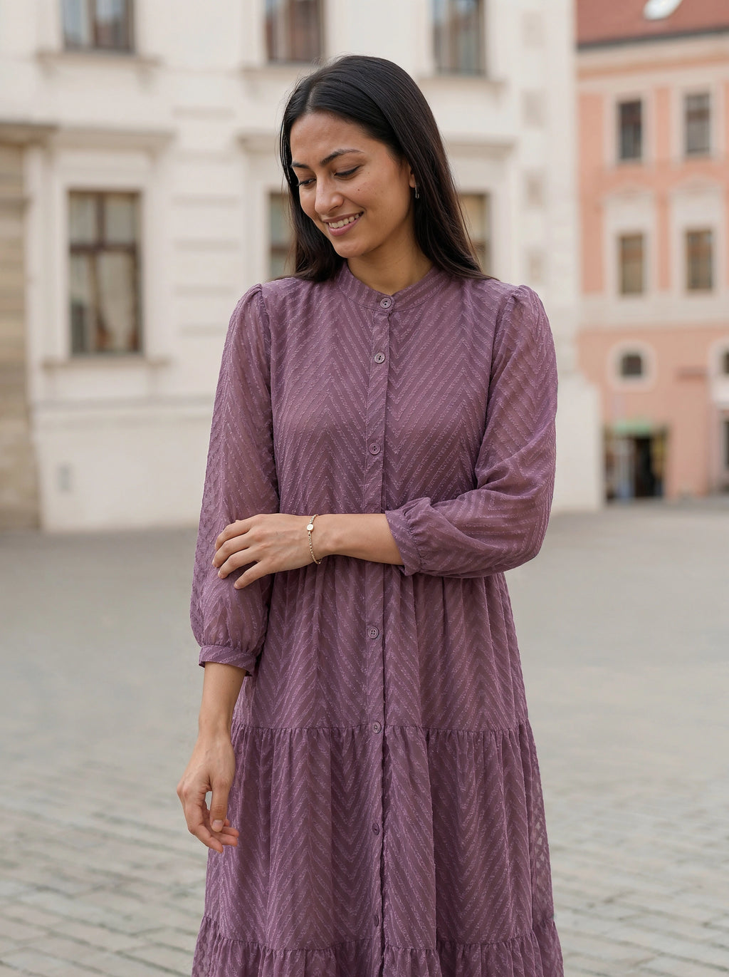 Woman wearing a purple dress standing in an urban setting