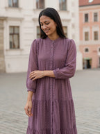 Woman wearing a purple dress standing in an urban setting