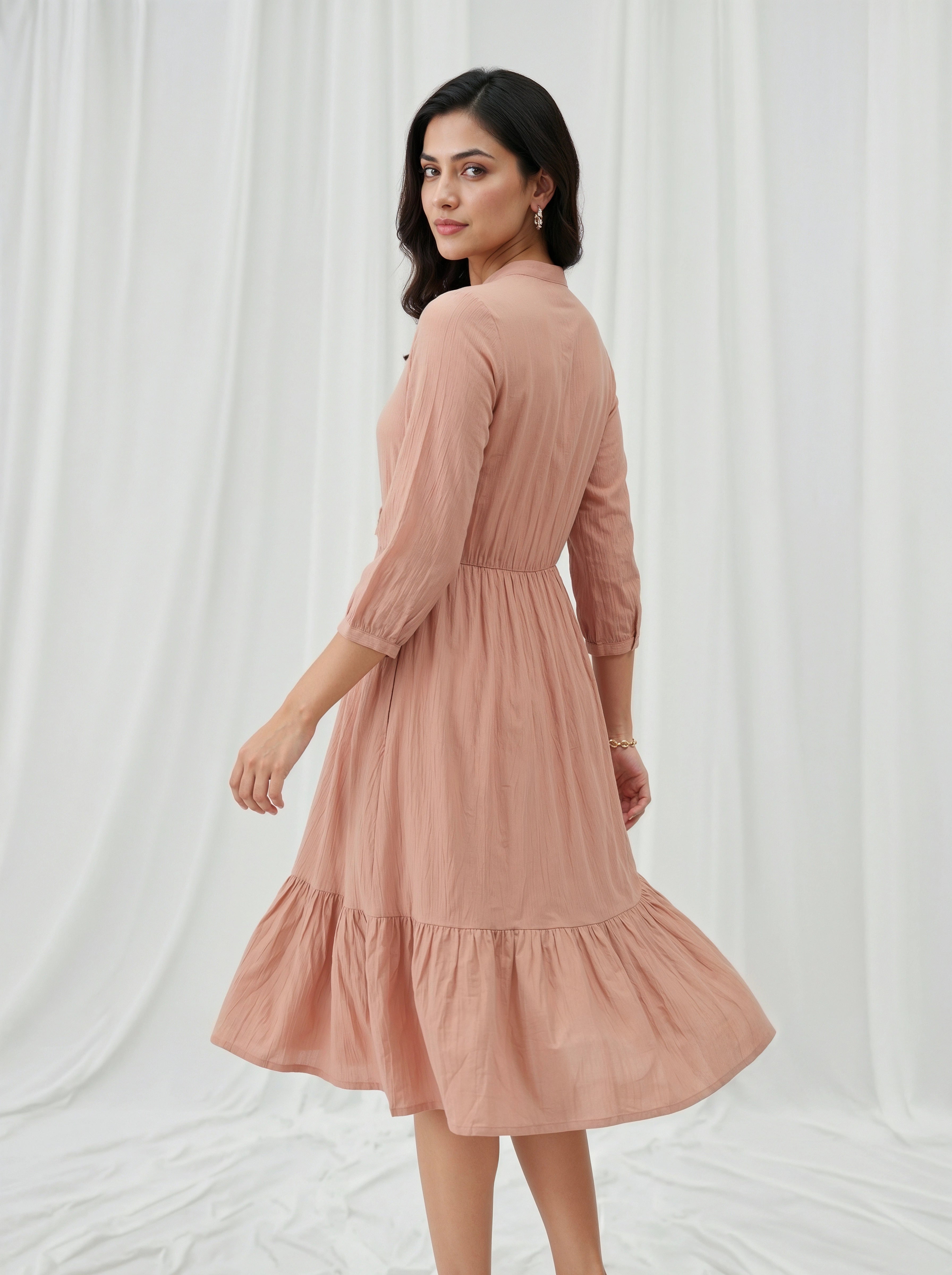 Woman wearing a pink dress against a white background