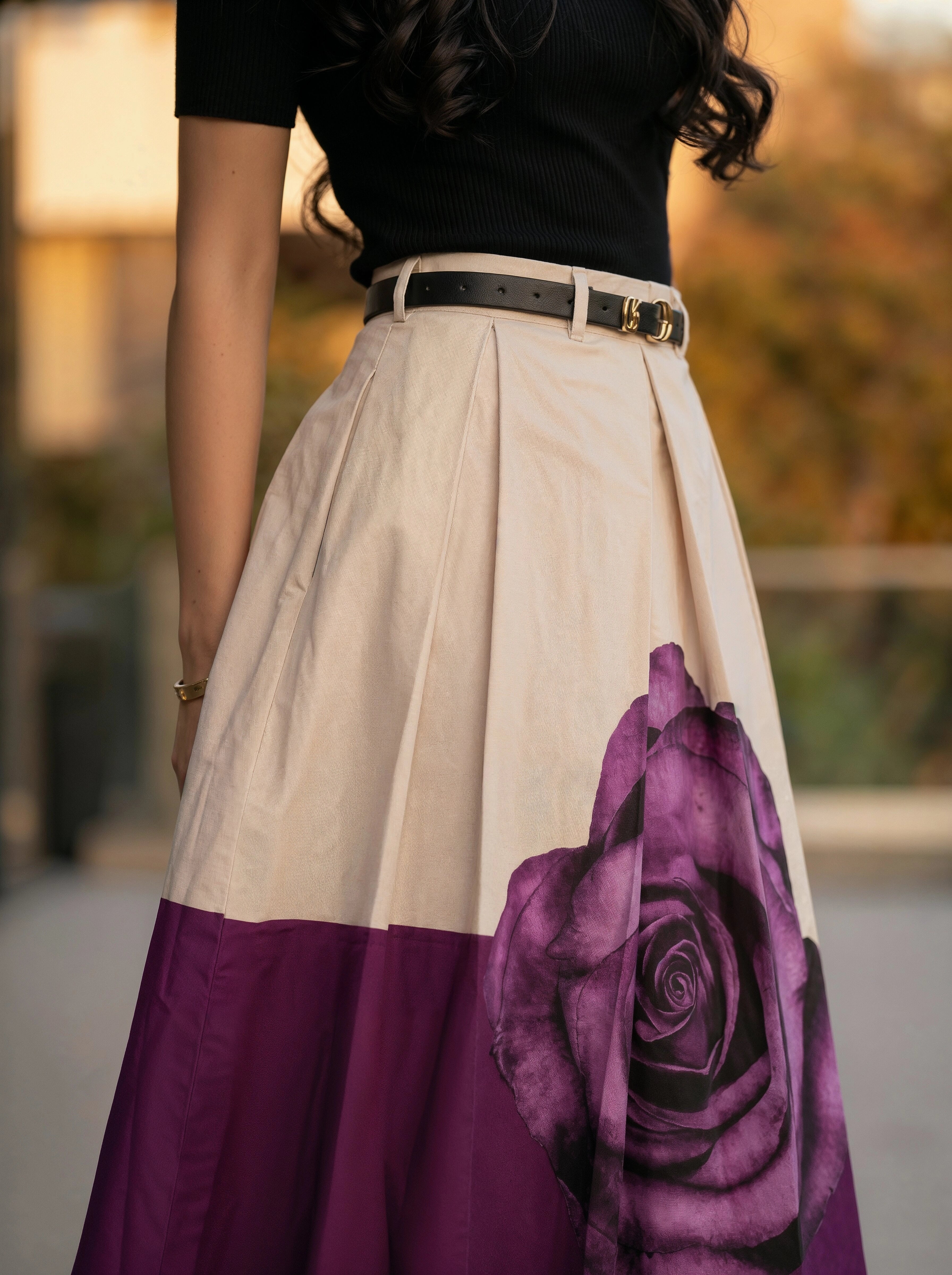 Woman wearing a skirt with a purple rose design outdoors