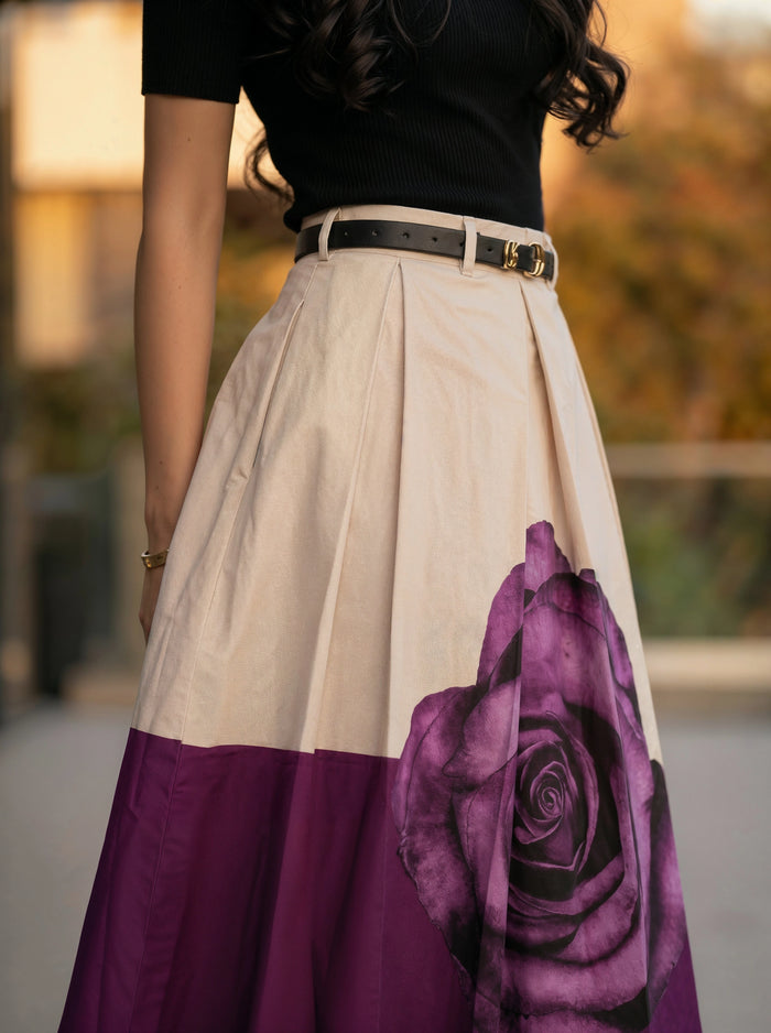 Woman wearing a skirt with a purple rose design outdoors