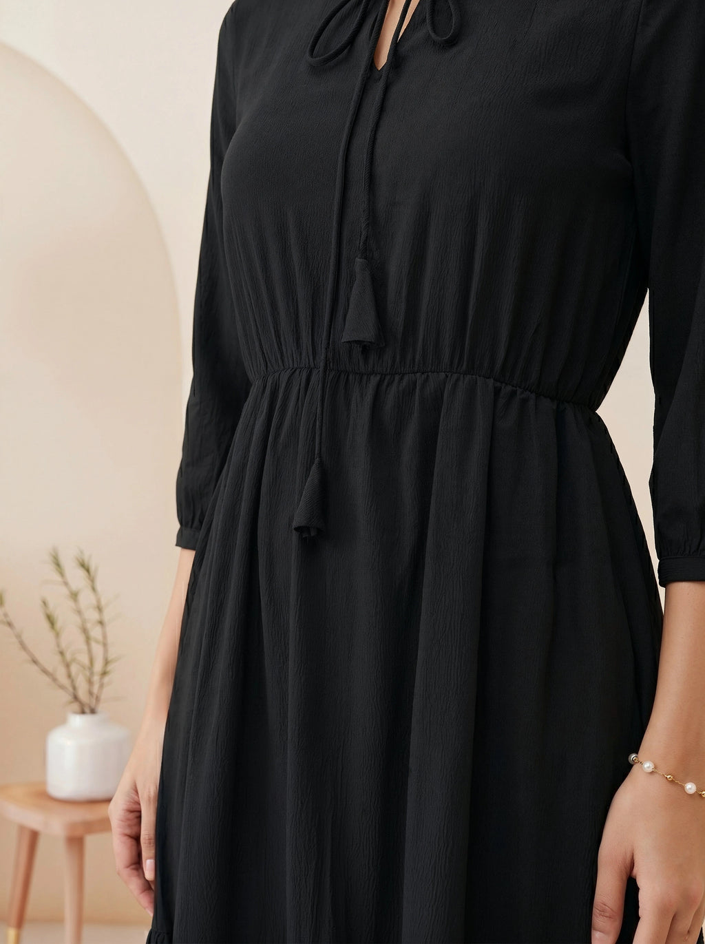 Black dress worn by a person with a neutral background
